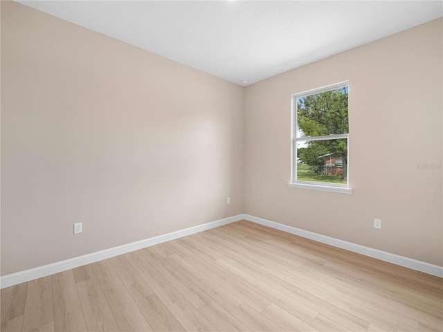 empty room featuring baseboards and light wood-type flooring