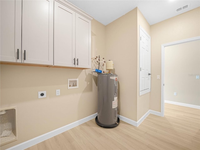 washroom with water heater, light wood-style floors, hookup for an electric dryer, cabinet space, and baseboards
