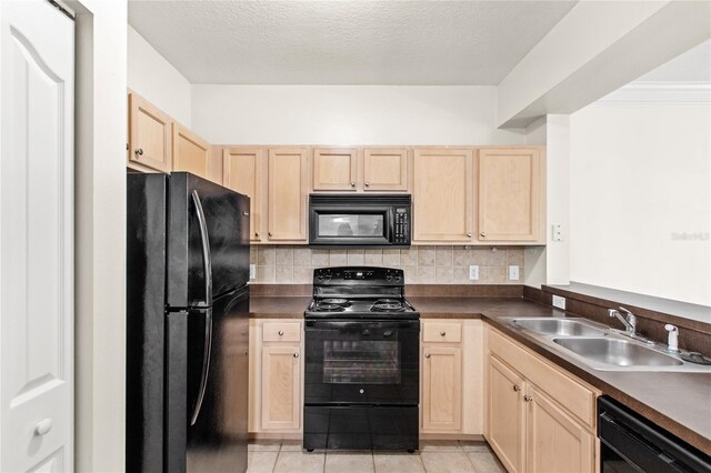 12843 Madison Pointe Cir Unit 106, Orlando, FL 32821 - kitchen featuring a sink, dark countertops, black appliances, and light brown cabinets