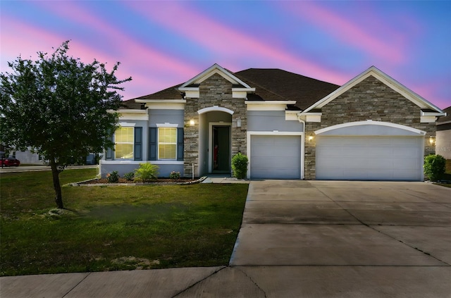 view of front of property featuring stone siding, a garage, stucco siding, a lawn, and driveway