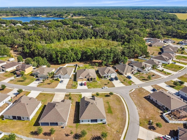 bird's eye view with a water view, a view of trees, and a residential view