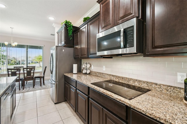 kitchen featuring dark brown cabinets, a chandelier, stainless steel appliances, decorative backsplash, and ornamental molding