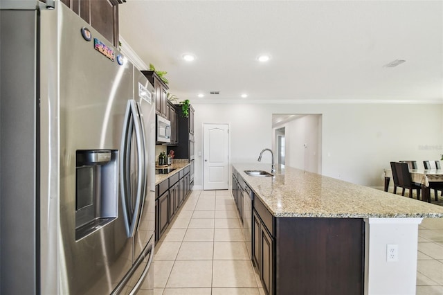 kitchen featuring crown molding, appliances with stainless steel finishes, dark brown cabinets, a sink, and light tile patterned floors