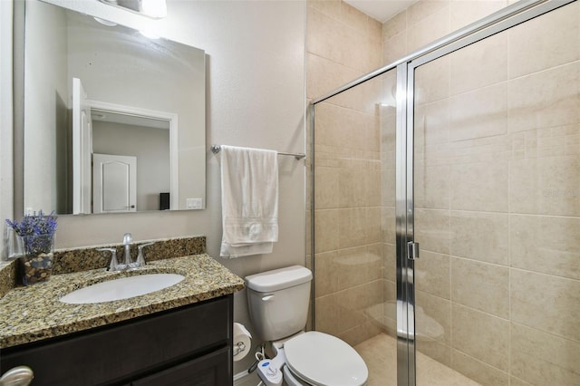 full bath with vanity, toilet, and a stall shower