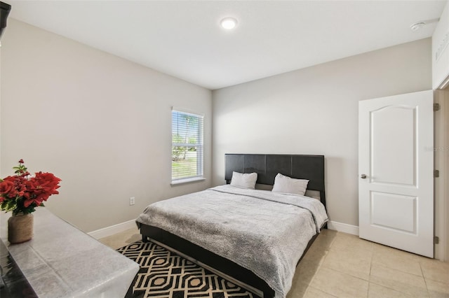 bedroom with baseboards and light tile patterned flooring