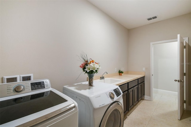 laundry room with independent washer and dryer, visible vents, cabinet space, a sink, and light tile patterned floors