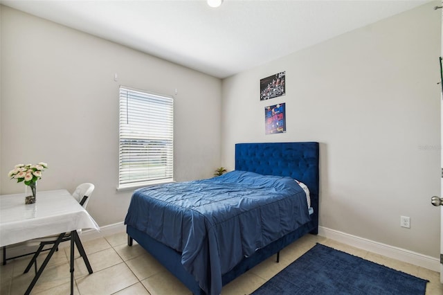 bedroom with baseboards and light tile patterned floors