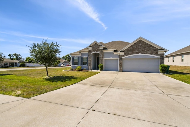 view of front of home with an attached garage, concrete driveway, a front yard, and stone siding