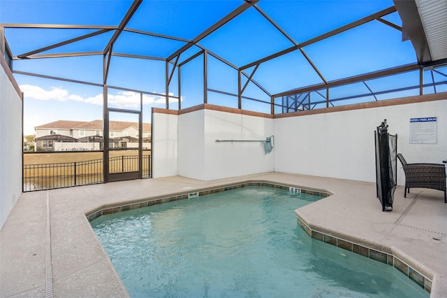 view of swimming pool featuring glass enclosure, a fenced in pool, and a patio area
