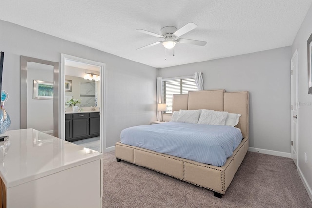 bedroom with light colored carpet, a textured ceiling, a ceiling fan, baseboards, and ensuite bathroom