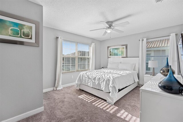 bedroom with baseboards, carpet, a ceiling fan, and a textured ceiling