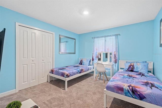 carpeted bedroom with a closet and baseboards