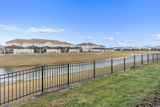 view of yard with a residential view, a water view, and a fenced backyard