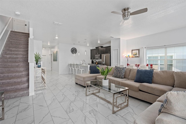 living area featuring ceiling fan, a textured ceiling, stairway, marble finish floor, and recessed lighting
