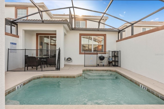 back of house with a patio, a lanai, a tile roof, and stucco siding