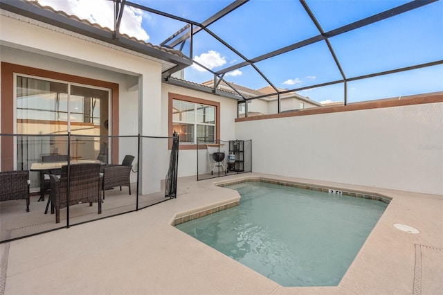 outdoor pool featuring glass enclosure and a patio area