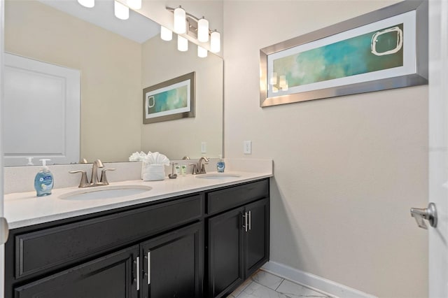 bathroom featuring baseboards, a sink, marble finish floor, and double vanity