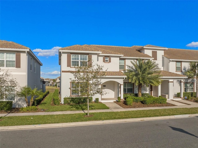 multi unit property with stucco siding and a tile roof