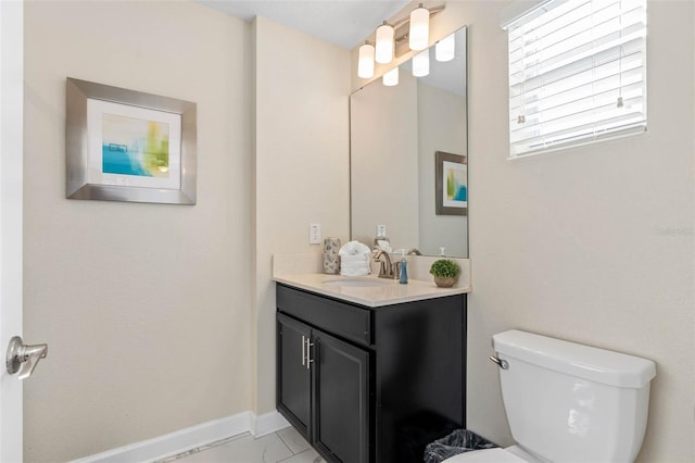 half bath featuring vanity, baseboards, and toilet