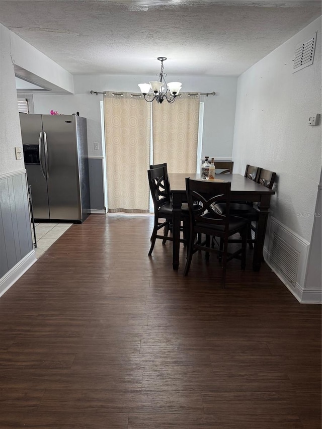 1238 Lakecrest Dr, Apopka, FL 32703 - dining room with a chandelier, wood finished floors, baseboards, a textured ceiling, and wainscoting