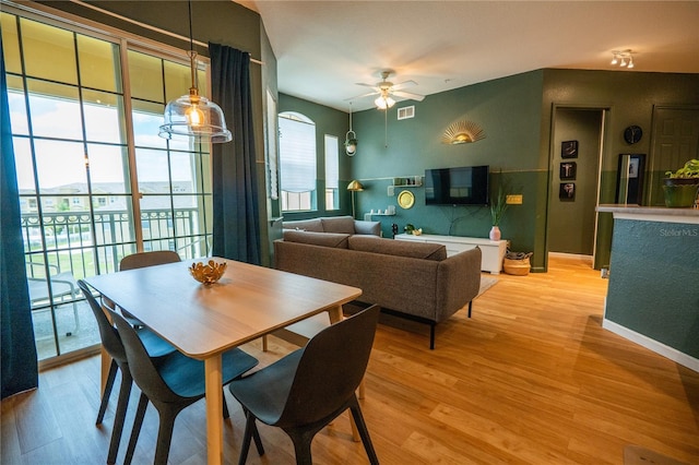dining area with baseboards, light wood finished floors, ceiling fan, and visible vents