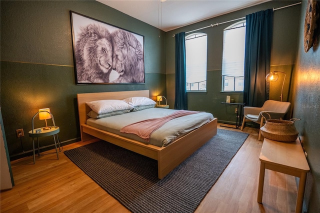 bedroom featuring a textured wall and wood finished floors
