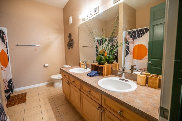 full bathroom with double vanity, toilet, tile patterned floors, and a sink