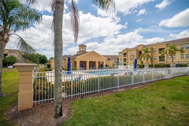 pool featuring a lawn and fence