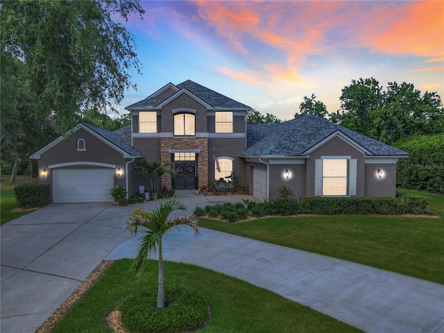 3008 Sutton Woods Dr, Plant City, FL 33566 - traditional home featuring an attached garage, stone siding, stucco siding, a lawn, and driveway