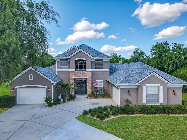 3008 Sutton Woods Dr, Plant City, FL 33566 - view of front of home with a front lawn, stone siding, a garage, stucco siding, and driveway