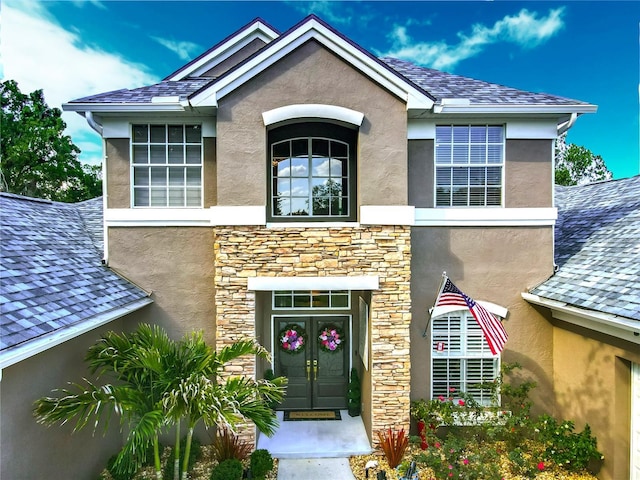 3008 Sutton Woods Dr, Plant City, FL 33566 - doorway to property featuring a shingled roof, stone siding, and stucco siding