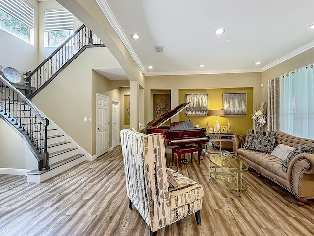 3008 Sutton Woods Dr, Plant City, FL 33566 - living room with ornamental molding, stairs, wood finished floors, and visible vents