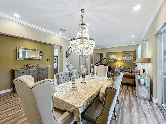 3008 Sutton Woods Dr, Plant City, FL 33566 - dining space featuring light wood-style floors, a chandelier, visible vents, ornamental molding, and stairway