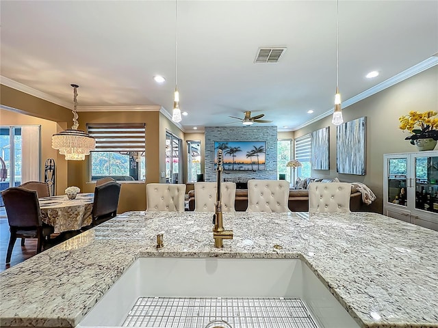 3008 Sutton Woods Dr, Plant City, FL 33566 - kitchen featuring a sink, plenty of natural light, open floor plan, visible vents, and ornamental molding