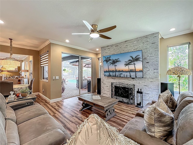 3008 Sutton Woods Dr, Plant City, FL 33566 - living area featuring a fireplace, ceiling fan with notable chandelier, baseboards, wood finished floors, and ornamental molding
