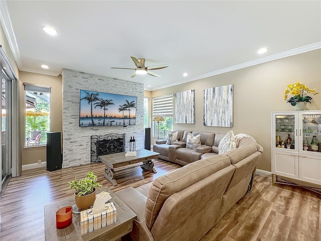 3008 Sutton Woods Dr, Plant City, FL 33566 - living room with crown molding, a ceiling fan, wood finished floors, and a fireplace