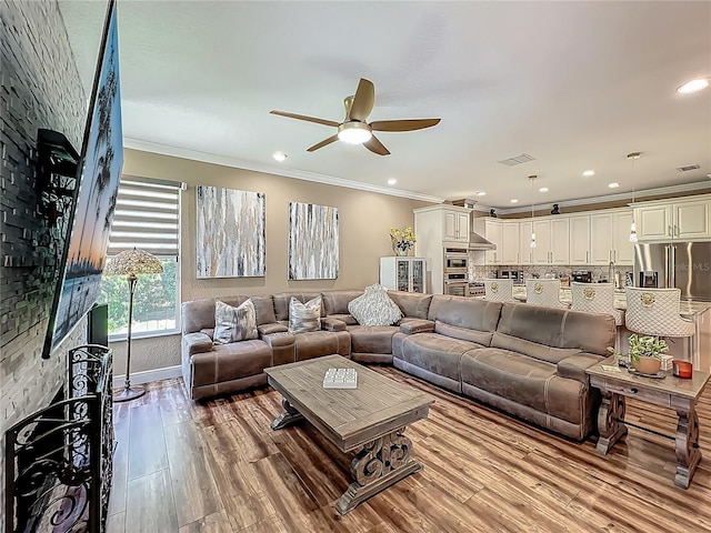 3008 Sutton Woods Dr, Plant City, FL 33566 - living area featuring crown molding, ceiling fan, wood finished floors, and visible vents