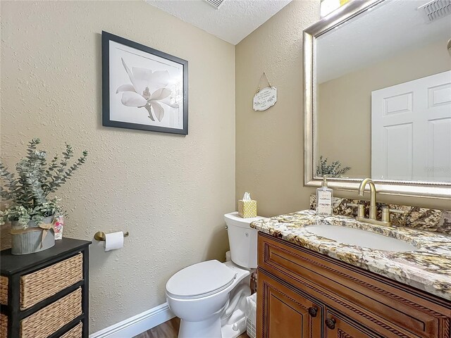 3008 Sutton Woods Dr, Plant City, FL 33566 - bathroom with a textured ceiling, visible vents, wood finished floors, vanity, and toilet