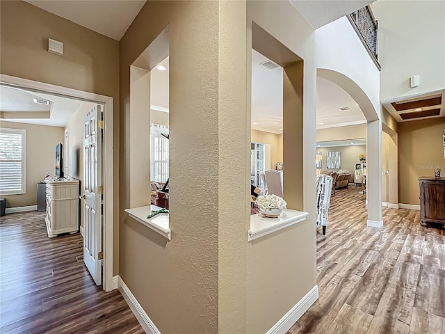 3008 Sutton Woods Dr, Plant City, FL 33566 - corridor featuring arched walkways, baseboards, visible vents, and wood finished floors