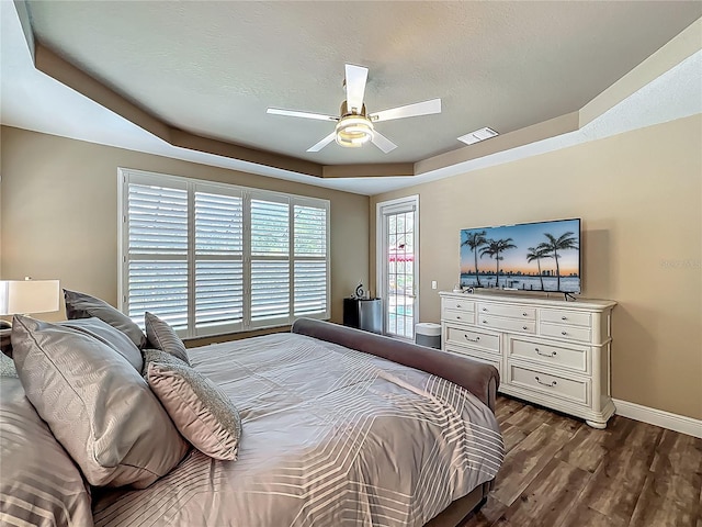 3008 Sutton Woods Dr, Plant City, FL 33566 - bedroom with ceiling fan, visible vents, dark wood finished floors, baseboards, and a tray ceiling