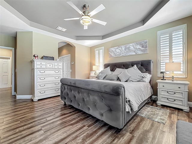 3008 Sutton Woods Dr, Plant City, FL 33566 - bedroom with visible vents, arched walkways, dark wood finished floors, a raised ceiling, and a closet