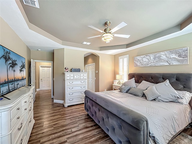 3008 Sutton Woods Dr, Plant City, FL 33566 - bedroom with arched walkways, dark wood finished floors, a raised ceiling, and visible vents