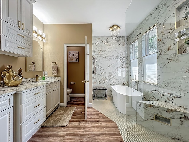 3008 Sutton Woods Dr, Plant City, FL 33566 - bathroom with a freestanding tub, vanity, toilet, and wood finished floors