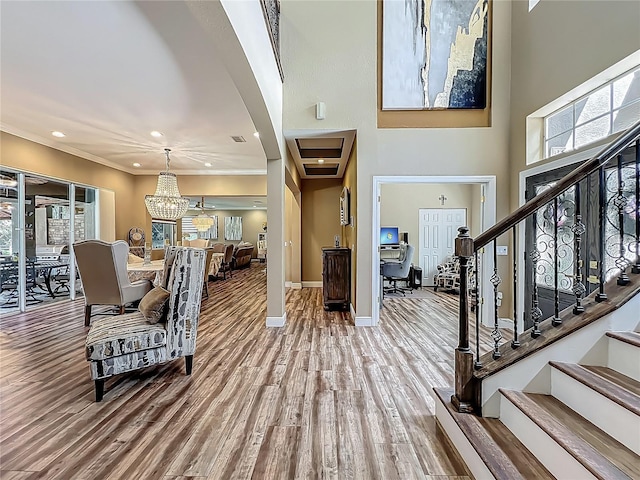 3008 Sutton Woods Dr, Plant City, FL 33566 - entryway with a notable chandelier, baseboards, wood finished floors, ornamental molding, and stairway
