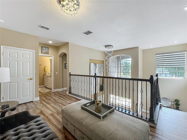 3008 Sutton Woods Dr, Plant City, FL 33566 - interior space featuring an inviting chandelier, arched walkways, an upstairs landing, wood finished floors, and visible vents