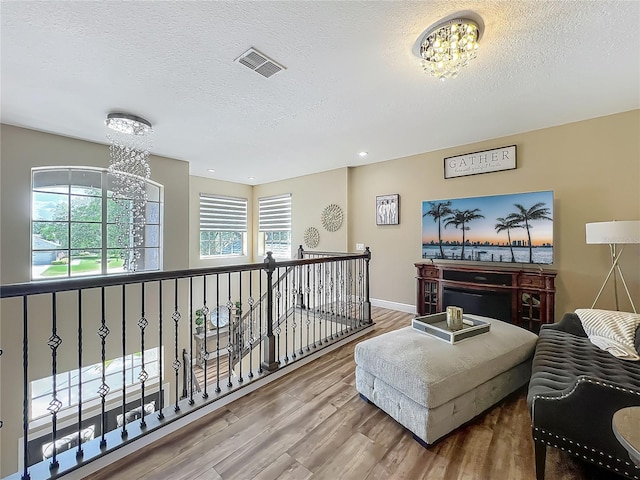 3008 Sutton Woods Dr, Plant City, FL 33566 - sitting room with a textured ceiling, an inviting chandelier, and wood finished floors