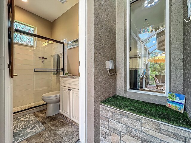 3008 Sutton Woods Dr, Plant City, FL 33566 - full bath with a textured wall, a tile shower, vanity, toilet, and stone tile floors