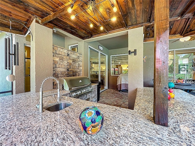 3008 Sutton Woods Dr, Plant City, FL 33566 - kitchen featuring a sink, wooden ceiling, a textured wall, and stone counters