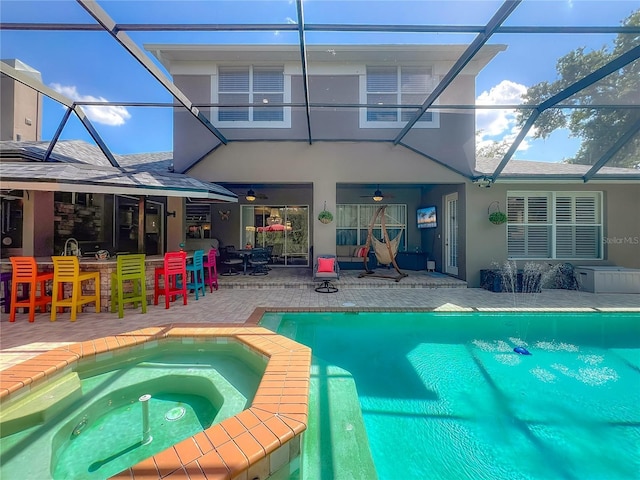 3008 Sutton Woods Dr, Plant City, FL 33566 - back of property featuring glass enclosure, a patio area, stucco siding, and ceiling fan