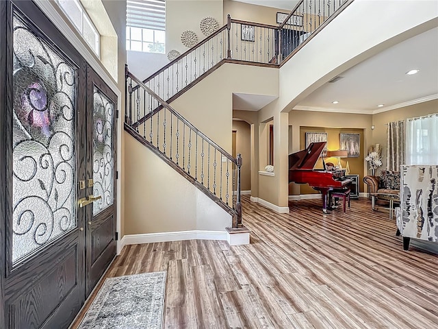 3008 Sutton Woods Dr, Plant City, FL 33566 - entrance foyer featuring arched walkways, wood finished floors, baseboards, ornamental molding, and stairs